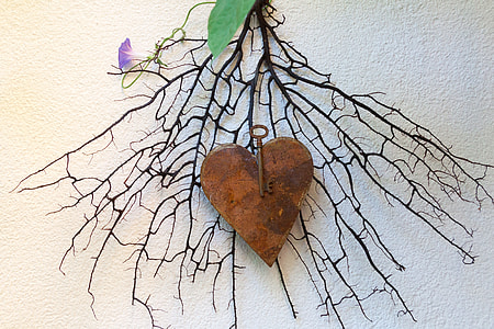black bare stem with brown heart accessory home decor on white painted wall thumbnail