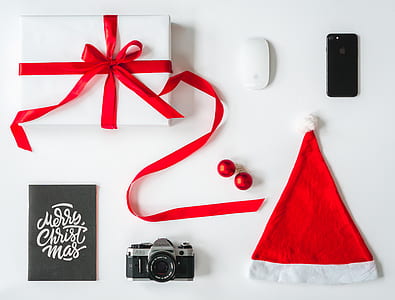 red Santa Claus hat beside camera and gift box thumbnail