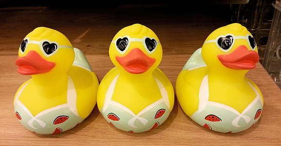 Three Cute Yellow Plastic Ducks in Their Bikinis. thumbnail