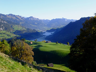 aerial view of green grass fields near mountains thumbnail
