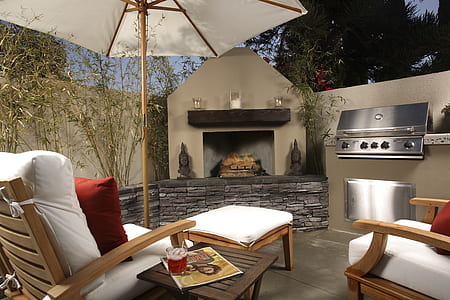 white parasol and two brown wooden armchairs near fireplace thumbnail