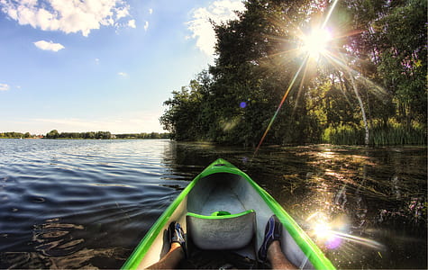 man in white and green canoe on body of water during daytime thumbnail