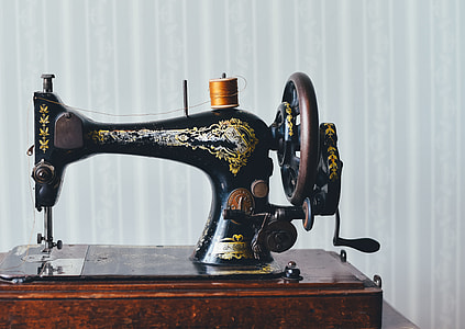 black and yellow hand crank table-top sewing machine thumbnail