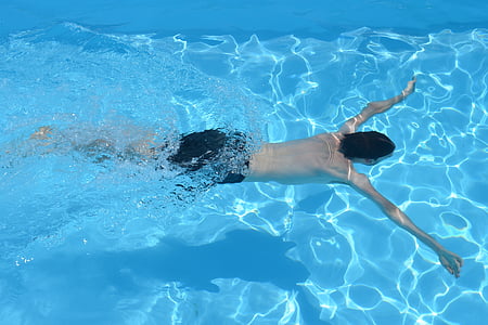 photo of man wearing black shorts swimming in pool thumbnail