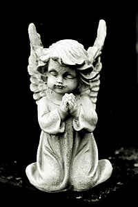 cherub praying figurine on top of black surface thumbnail