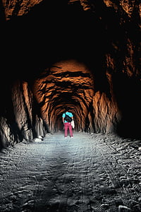 man standing inside cave with light passing trough thumbnail