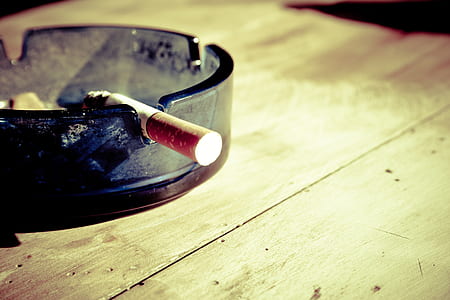 single cigarette on glass ashtray thumbnail