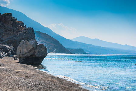 rock formation near beach under blue sky thumbnail