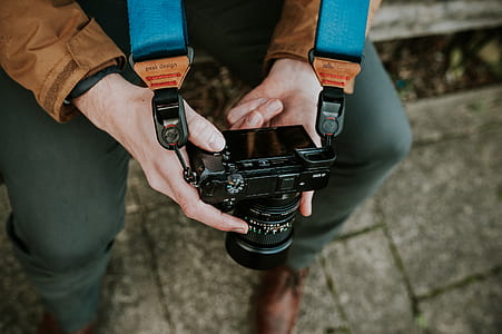 person holds camera with strap white sitting thumbnail