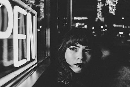 grayscale photography of woman looking at OPEN neon signage thumbnail