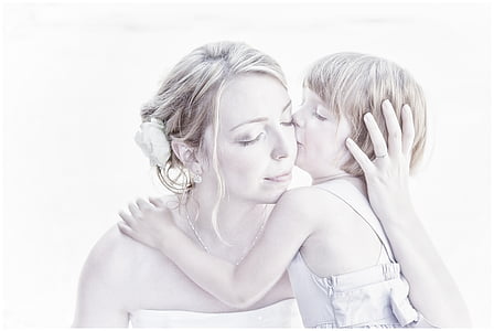 girl kissing woman on cheek thumbnail