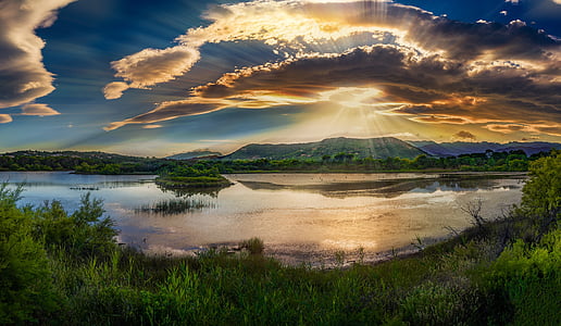 panorama photography of body of water under cloudy sky thumbnail