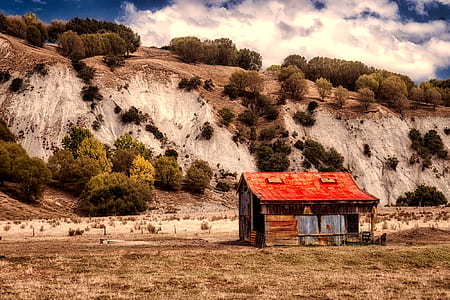 brown wooden house near mountain thumbnail