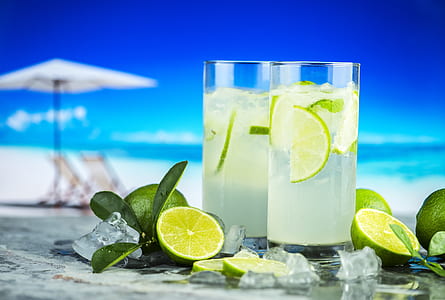 two clear drinking glass with liquid and lime fruits thumbnail