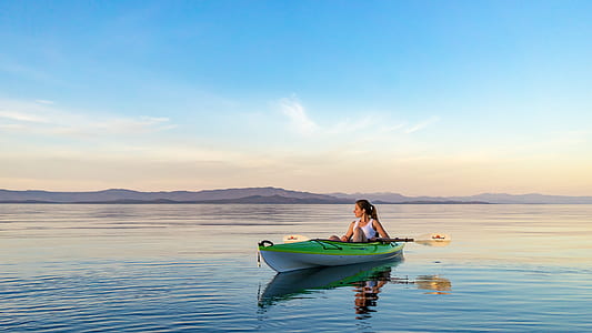 woman riding kayak under blue sky thumbnail