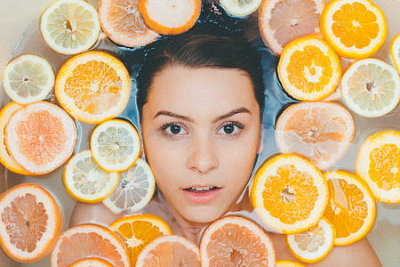 woman on body of water with slice of orange fruits thumbnail
