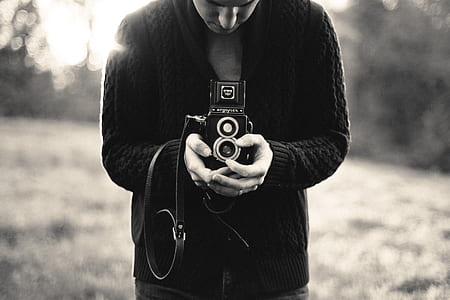 person in black robe holding land camera thumbnail