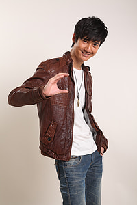 man standing beside white wall thumbnail