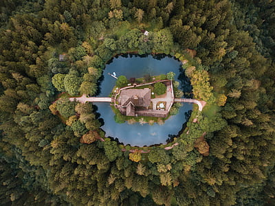 bird's eye view of grey house surrounded by body of water thumbnail
