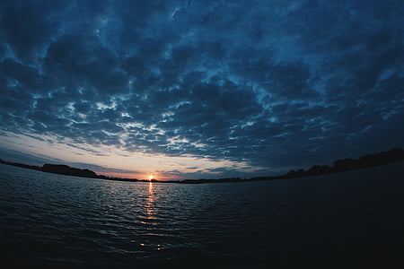 body of water under cloudy sky during sunset thumbnail