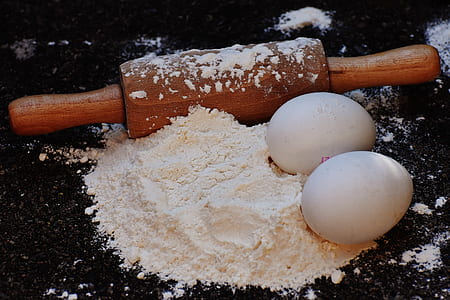 white eggs on flour with rolling pin thumbnail