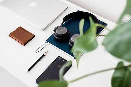 headphone on top of notebook on white table thumbnail