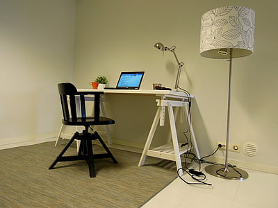 black laptop on white desk with chair at side of lamp thumbnail