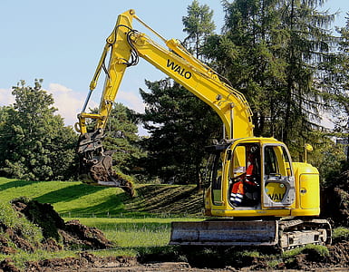 yellow excavator on green field thumbnail