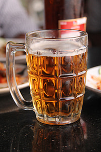 nearly filled glass beer mug on black counter top thumbnail