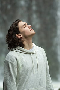 man wearing gray hoodie looking up in selective focus photography thumbnail