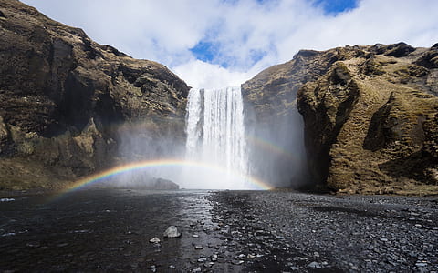 waterfalls between brown mountain during daytime thumbnail
