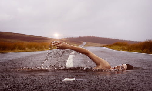 edited photo of man swimming on asphalt road thumbnail