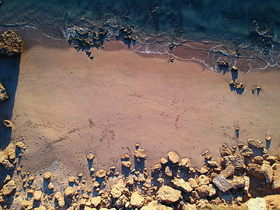aerial photography of seashore with rocks thumbnail
