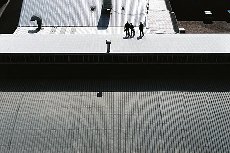 three person on gray galvanized iron sheet during day time thumbnail