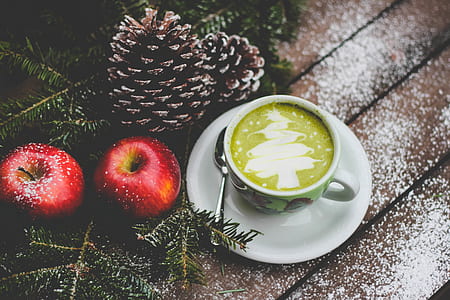 white ceramic teacup with liquid near two apples thumbnail