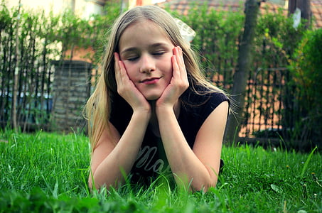woman lying on grass field during daytime thumbnail