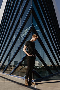 man standing on concrete floor near building thumbnail