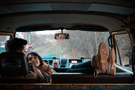 man and woman inside the car parked near trees thumbnail