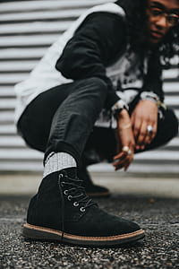 person wearing black suede lace-u boot near gray roller shutter thumbnail