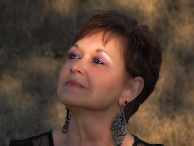 closeup photo of woman wearing pair of silver-colored chandelier earrings thumbnail