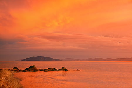 rocks surrounded by ocean during sunset thumbnail