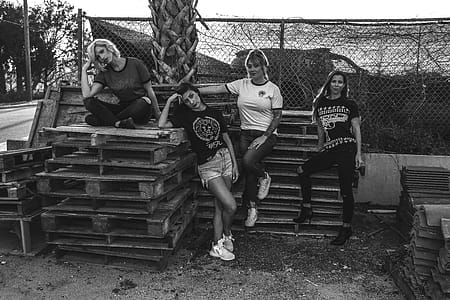 Four Women Leaning and Sitting on Pallets thumbnail