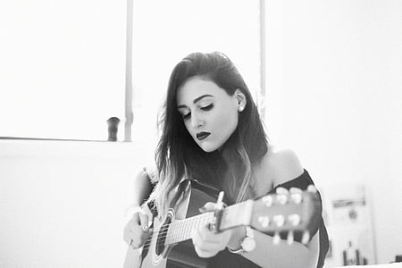 grayscale photography of woman playing guitar thumbnail