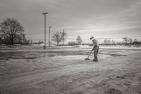 grayscale photography of man cleaning pavement thumbnail