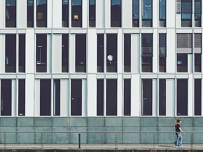 man walking on pavements near building thumbnail