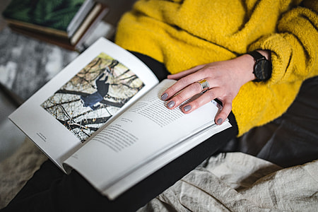 Young woman reading a magazine in bed thumbnail