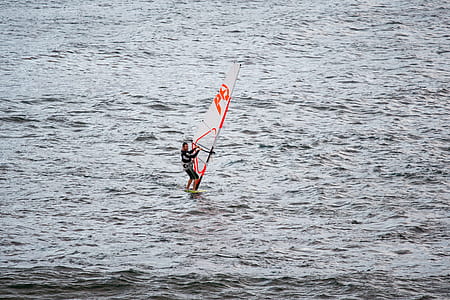 man windsurfing on body of water thumbnail
