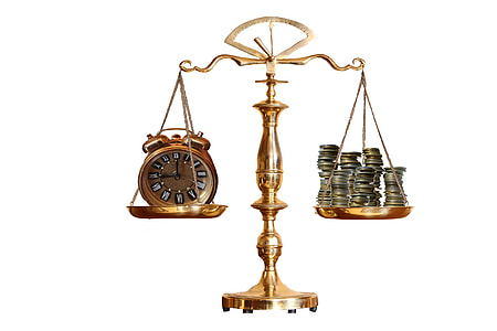 brass-colored balance scale with analog clock and coins thumbnail
