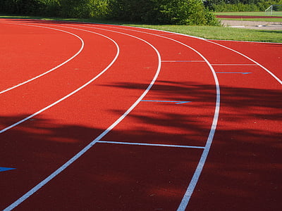 red running field beside green grass thumbnail