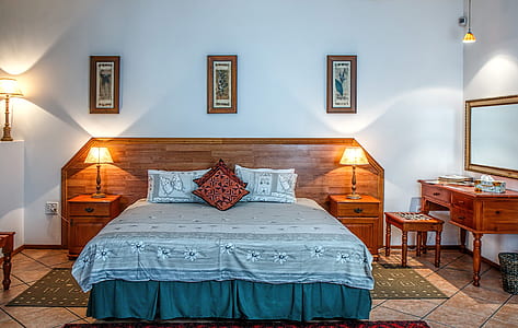 brown wooden bed with green and white floral comforter set thumbnail